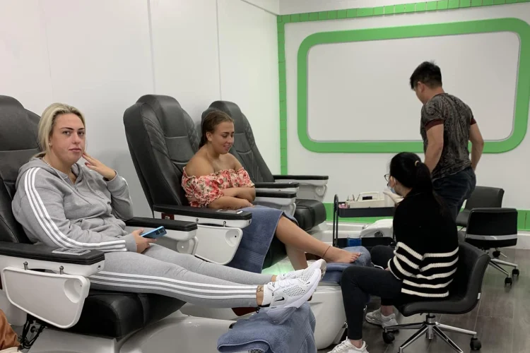 2 women sitting in pedicure seats getting pedicure treatment