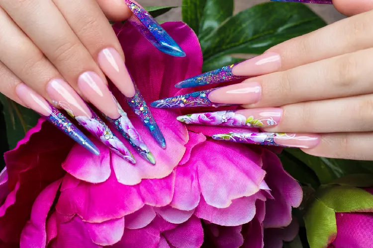 Long beautiful manicure with flowers on female fingers. Nails design. Close-up
