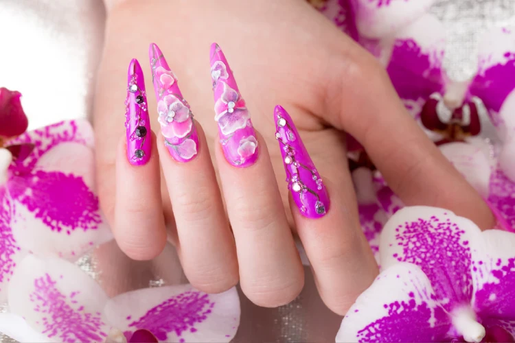 Long beautiful manicure with flowers on female fingers. Nails design.